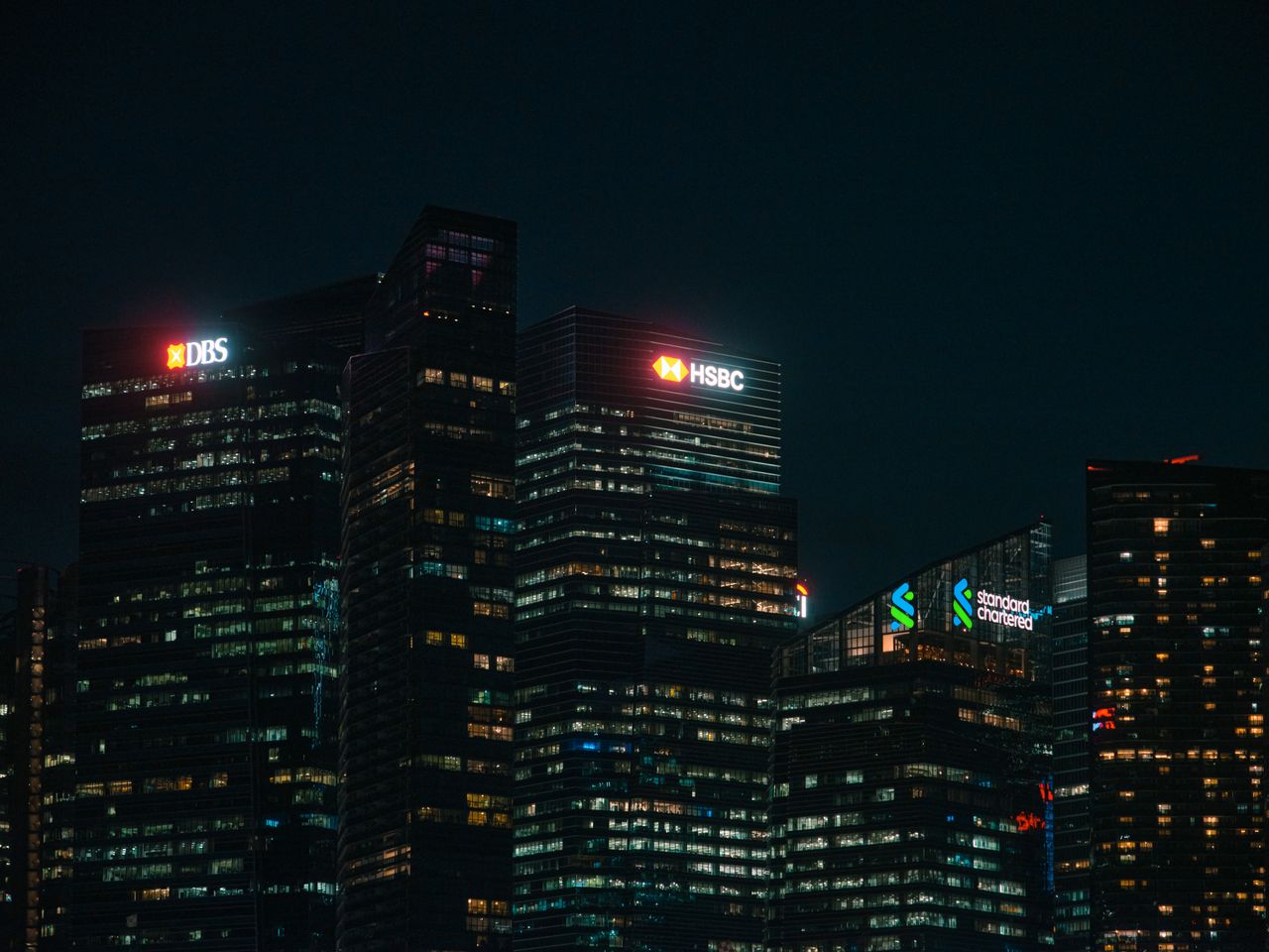 The Art of Drawing Readers In: Your attractive post title goes here Illuminated city skyscrapers of major banks in Singapore's financial district at night.