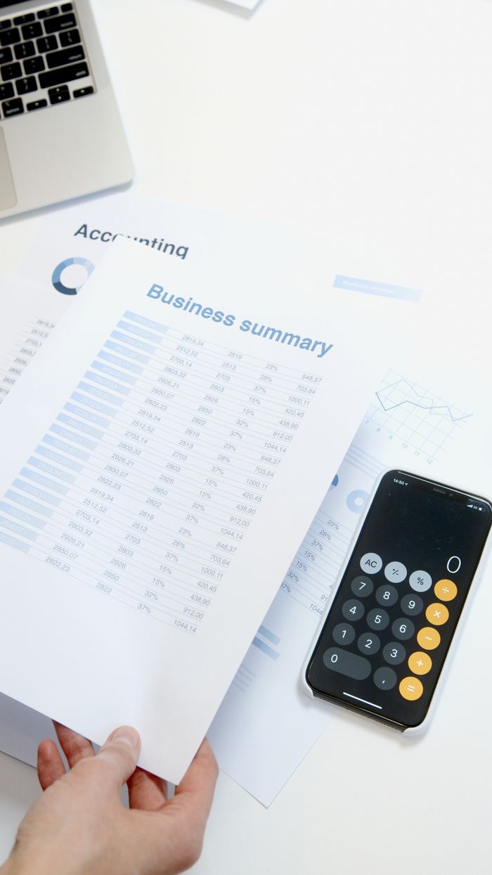 Usługi Business summary sheet with a calculator on a desk for financial analysis.